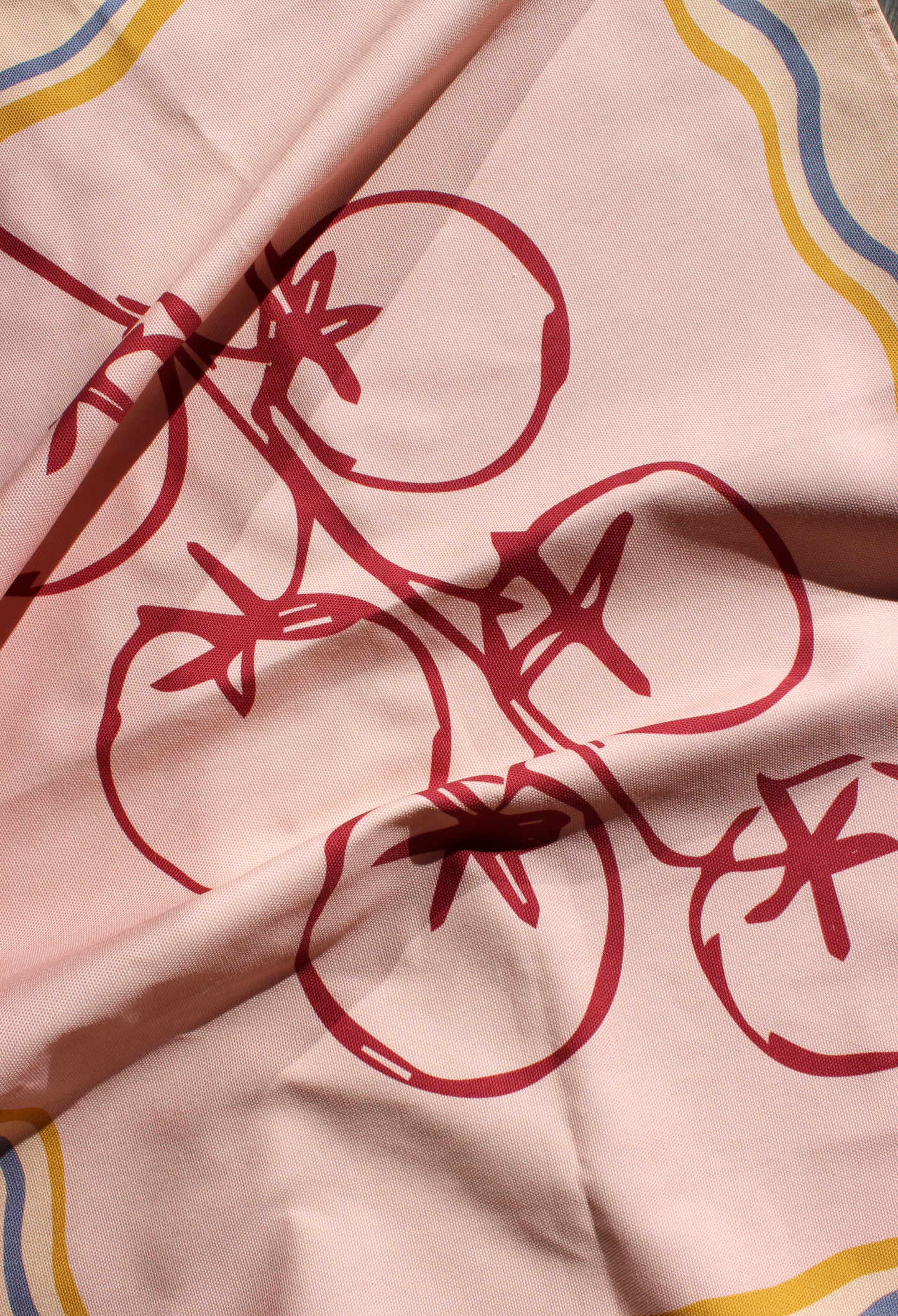 Close-up of fabric with red tomato pattern on a pink background