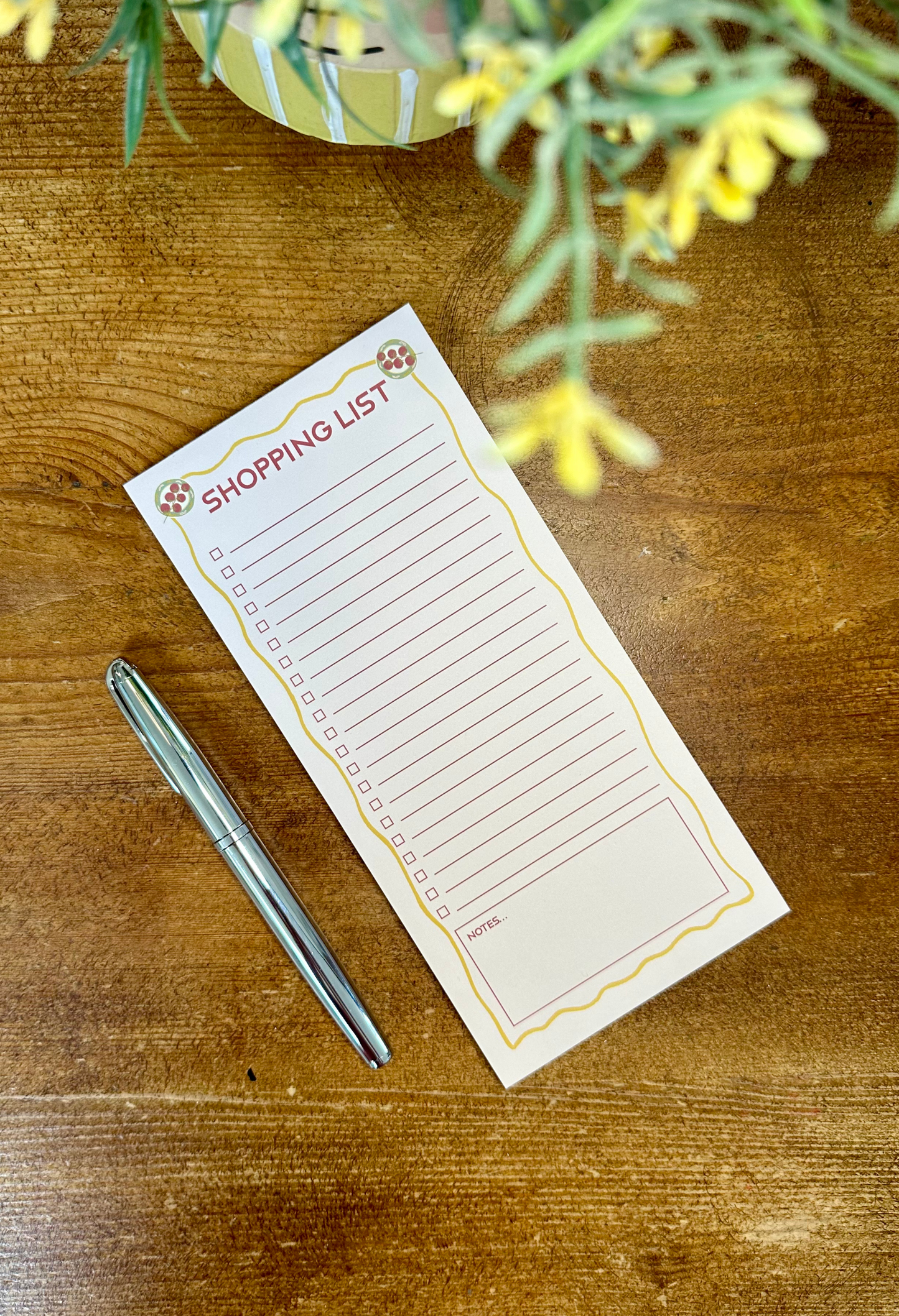 Shopping list notepad on table with pen
