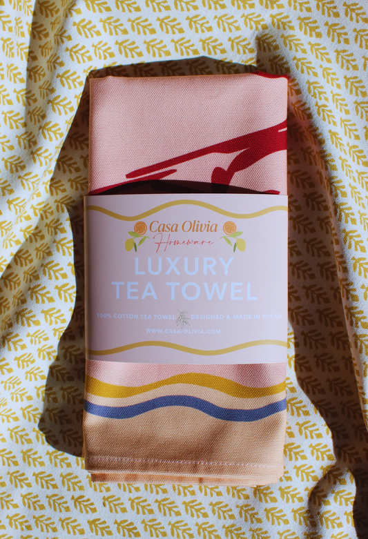 Casa Olivia luxury tea towel with decorative packaging on a patterned background
