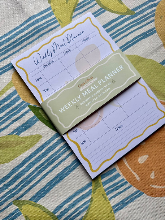 Weekly meal planner on a fabric background with pumpkins
