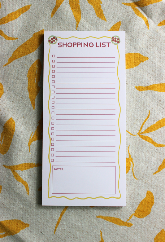 Shopping list notepad on fabric background