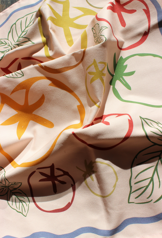 Close-up of tea towel fabric with colorful patterns and text
