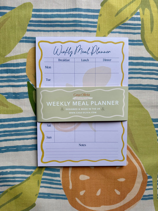 Weekly meal planner on a colorful fabric background
