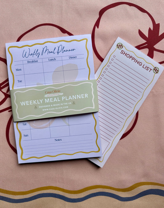 Weekly meal planner and shopping list on a patterned surface
